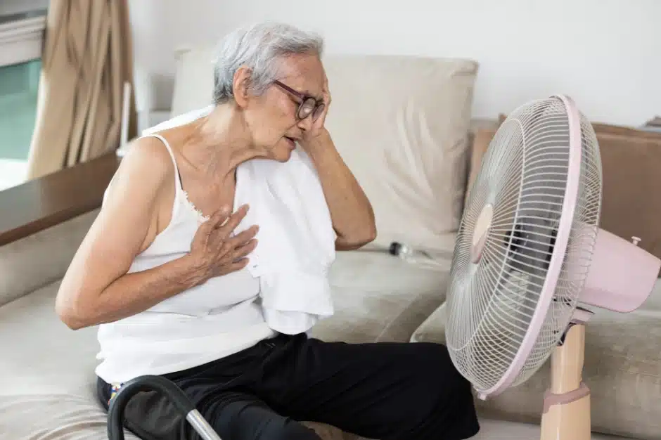 heatstroke in nursing home residents, elderly woman sitting on bed with an exhausted look near fan, Disparti Law Group