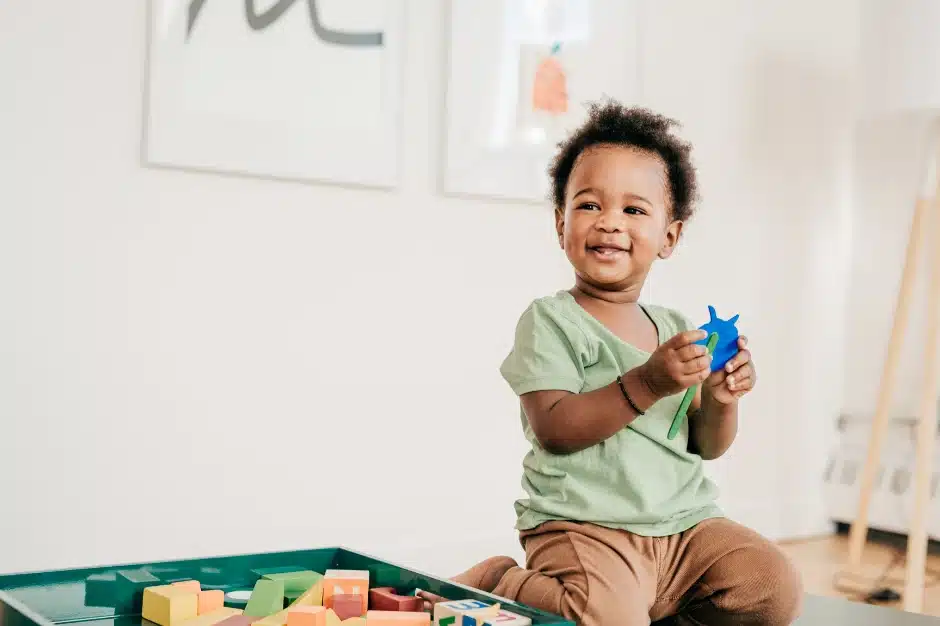 most dangerous toy recalls in 2024, Image of toddler playing with toys sitting on knees, Disparti Law Group