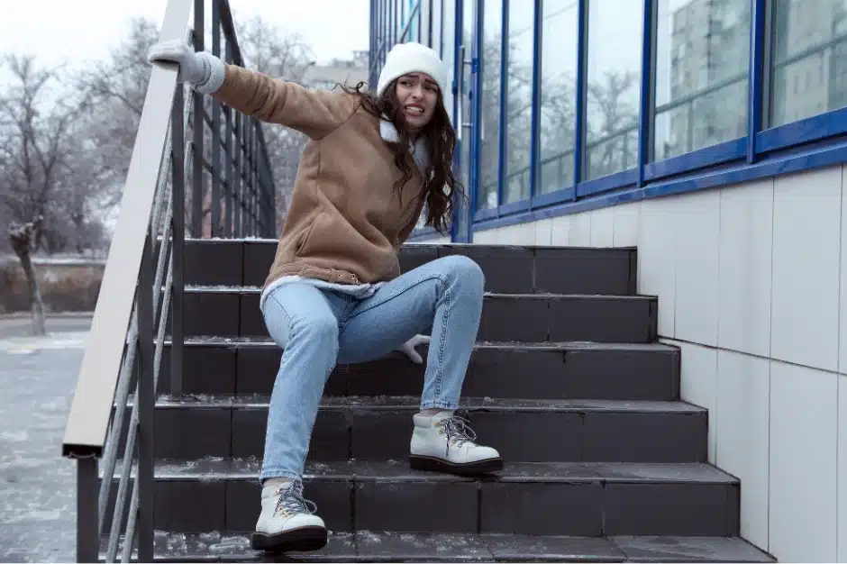 image of woman slipping on ice down stairs.