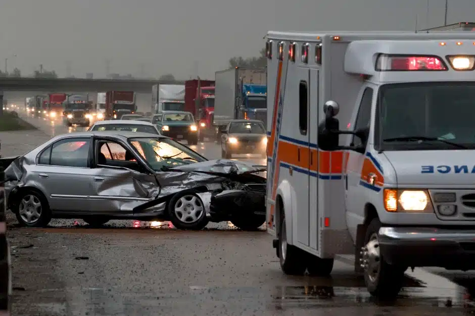 sue after a car accident, image of crashed vehicle next to ambulance in stopped traffic, Disparti Law Group